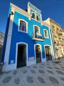 un edificio blu e bianco con balcone di Janelas da Praça a Miranda do Corvo