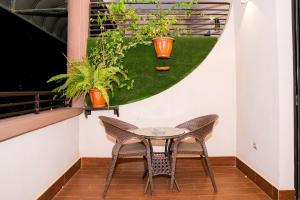 uma mesa e cadeiras numa varanda com plantas em Hotel Hibiscus em Bujumbura
