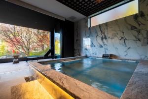 una gran piscina en una habitación con una gran ventana en Gekkoju Yufuin en Yufuin