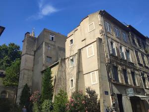 un antiguo edificio con una torre a un lado. en Appartement climatisé parking gratuit surveillé, en Aviñón