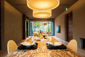 a dining room with a large wooden table with chairs at Gekkoju Yufuin in Yufu