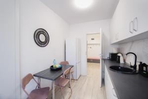 a small kitchen with a table and a sink at Pinky Black Escape in Oradea