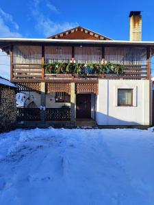 a house with snow in front of it at Карпатський куточок in Slavske