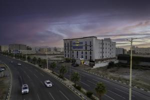 una autopista con un edificio y coches en la carretera en Gardenia Furnished Units, en Jazan