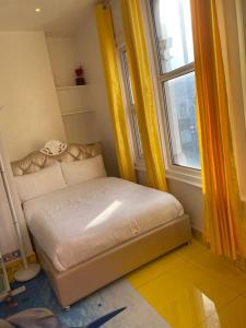 Cama pequeña en habitación con ventana en Ziggla Luxury Properties, en Londres