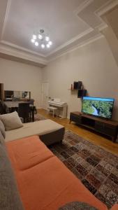 a living room with a couch and a flat screen tv at Kristal Sumqayıt in Sumqayıt