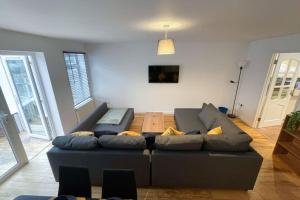 a living room with a couch and a tv at Spacious House in Brighton with large garden and free parking in Falmer