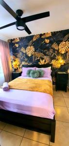 une chambre avec un grand lit avec un ventilateur de plafond dans l'établissement El Encanto Condominiums, à Jacó