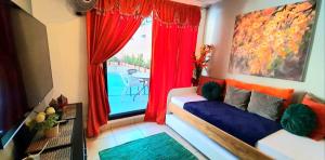 a room with a couch and a window with a table at El Encanto Condominiums in Jacó