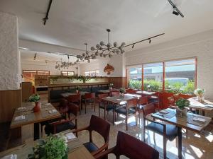 um restaurante com mesas e cadeiras de madeira e janelas em Hotel Dralha em Thimphu
