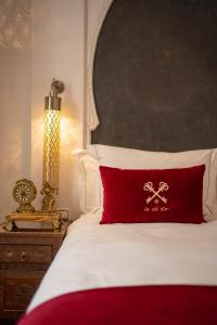 Riad la clé d'or & spa في مراكش: سرير ومخدة حمراء عليها صليب