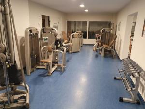 un gimnasio con un montón de pisadas y máquinas en Ferienwohnung Winklworld 2 mit Hallenbad und Sauna inklusive aktivCARD en Sankt Englmar