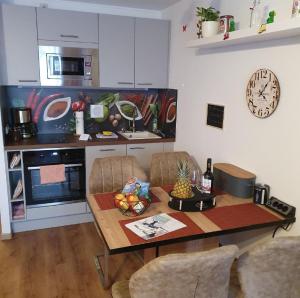 uma cozinha com uma mesa e uma cozinha com um relógio em Ferienwohnung Winklworld 2 mit Hallenbad und Sauna inklusive aktivCARD em Sankt Englmar