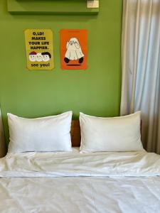 uma cama com três cartazes numa parede verde em Rightday Inn em Dongshan