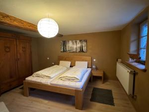 una camera da letto con un letto e un lampadario di Schöneberger Bauernhof - Hühnerhaus a Schöneberg Altre 6 foto
