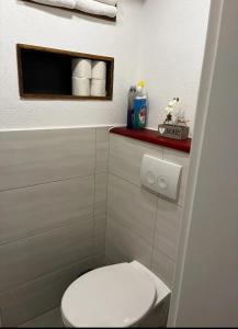 a bathroom with a white toilet and a red shelf at Lilly in Meßkirch