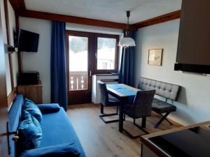 a living room with a blue couch and a table at Haus Renate in Lermoos
