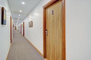 a corridor of halls with wooden doors and a carpet at Super OYO Townhouse 1232 White Sand in Dehradun