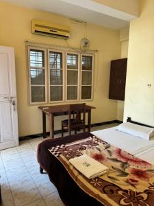 a room with a bed and a table and a window at Aambal Residency in Cochin