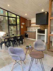 a living room with a table and chairs and a kitchen at DEPARTAMENTOS ESPACIO PUCON in Pucón
