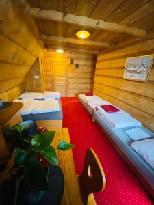 a room with three beds in a wooden room at Bukovina Concept Mountain in Bukowina Tatrzańska