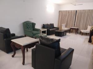 - un salon avec des canapés, des chaises et une table dans l'établissement Royal Nest 4 BHK, à Pune