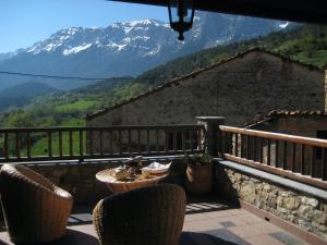 einen Balkon mit einem Tisch, Stühlen und einem Berg in der Unterkunft Casa Rural al Pirineu in Ansobell