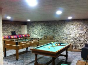 Habitación con mesa de billar y pared de piedra. en Casa Rural al Pirineu, en Ansobell