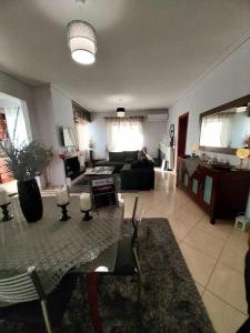 a living room with a table and a couch at Thira Apartment near Athens Airport in Spata