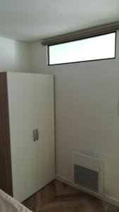 Dieses weiße Zimmer verfügt über eine Tür und ein Fenster. in der Unterkunft Gîte de l'étang des sarcelles in Saint-Martin-dʼAubigny