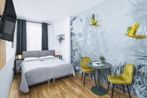 a bedroom with a bed and a table and yellow chairs at Pappagallo Apartments in Vienna