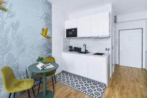 a kitchen with a small table and chairs and a door at Pappagallo Apartments in Vienna