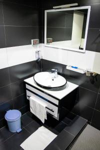 a bathroom with a sink and a mirror at Hotel Hibiscus in Bujumbura