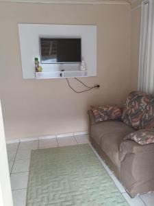 een woonkamer met een bank en een flatscreen-tv bij RECANTO DA IZAURINHA in Olímpia