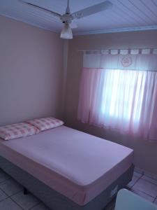 een slaapkamer met een bed en een plafondventilator bij RECANTO DA IZAURINHA in Olímpia