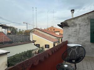 a chair sitting on a balcony of a building at Welc-oM Savonarola river view in Padova