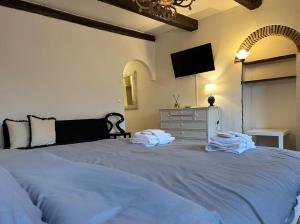 a bedroom with a large bed with towels on it at Welc-oM Savonarola river view in Padova