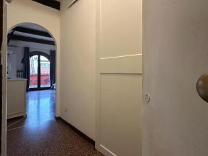 an empty hallway with a door and an archway at Welc-oM Savonarola river view in Padova