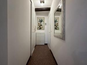 a hallway with white walls and a hallway with a mirror at Welc-oM Savonarola river view in Padova +89 photos