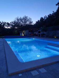 a swimming pool with blue water at night at Villa MirIva in Katuni