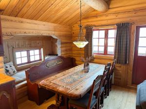 a dining room with a wooden table in a cabin at Skibyen Jons Hytte in Skoro