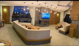 duży salon z kanapą i telewizorem w obiekcie LİON HİLL RESORT w mieście Sarıkamıs