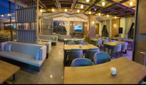 een restaurant met tafels en banken en tafels en stoelen bij LİON HİLL RESORT in Sarıkamıs