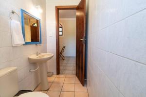 een badkamer met een wastafel, een toilet en een spiegel bij Pousada Maré de Lua in Florianópolis