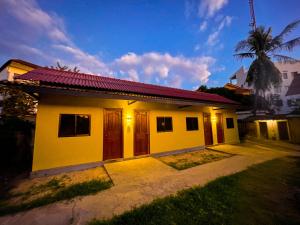 ein kleines gelbes Haus mit rotem Dach in der Unterkunft BLANK GUEST HOUSE in Siem Reap