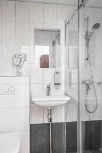 uma casa de banho com um lavatório e um chuveiro em Hotel City Garden Amsterdam em Amesterdão