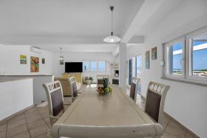 a dining room and kitchen with a table and chairs at Grande Villa Horizon in Makarska