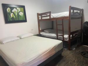 1 Schlafzimmer mit 2 Etagenbetten und einem Gemälde an der Wand in der Unterkunft MARIBAO in Playas