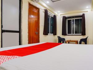 a bedroom with a large white bed and a wooden door at OYO Flagship Hotel Moonlight in Rāipur