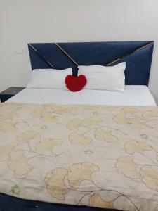 a bed with a red heart pillow on top of it at STAR HOTEL in Bahādurgarh